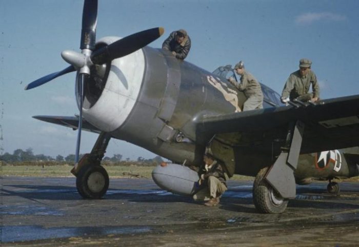 The ground crew servicing the Republic P-47 Thunderbolt flown by Captain Johnson. Sergeant George Baltimore is working on the petrol tank, Corporal Jack Kazanjac on top of the engine, Sergeant Howard Buckner by the cockpit, and Private Albert Asplint on the wing.