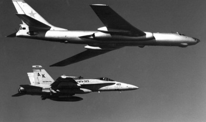 A Soviet Tupolev Tu-16 Badger aircraft being escorted by a U.S. Marine Corps McDonnell Douglas F/A-18A Hornet aircraft from Marine fighter-bomber squadron VFMA-323 Death Rattlers in 1985.