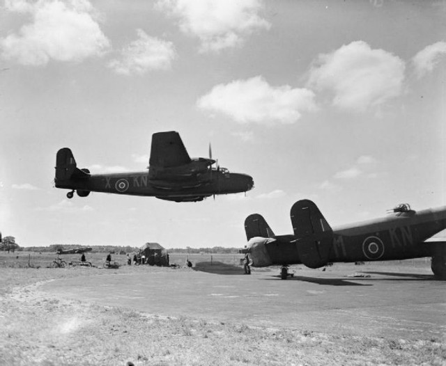 Halifax B Mark II Series 1 (Special), JB911 KN-X, of No. 77 Squadron RAF, making a low level pass over other aircraft of the squadron at Elvington, Yorkshire.