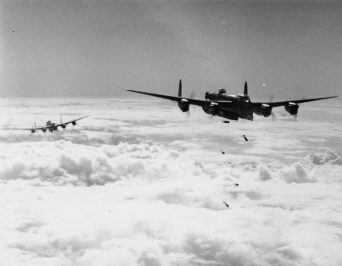 An Avro Lancaster B Mark I or III releases its bombs through cloud, during a daylight attack on a flying-bomb launch site at Les Catelliers in northern France.