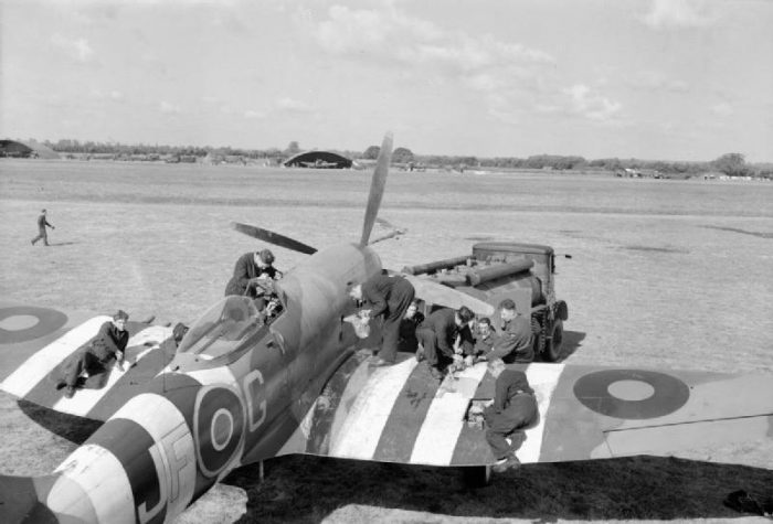 Ground crew refuel and rearm a Hawker Tempest. The stripes on top of the wings and fuselage signify this image was most likely taken in June 1944.