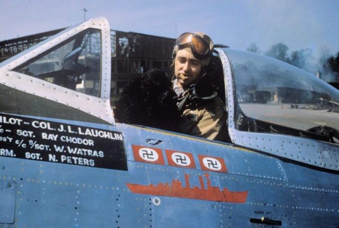 Colonel J.L. Laughlin, of the 362nd Fighter Group, smokes a cigar with his dog mascot “Prince” inside the cockpit of his P-47D serial 44-33287 “Five By Five” (coded B8-A)