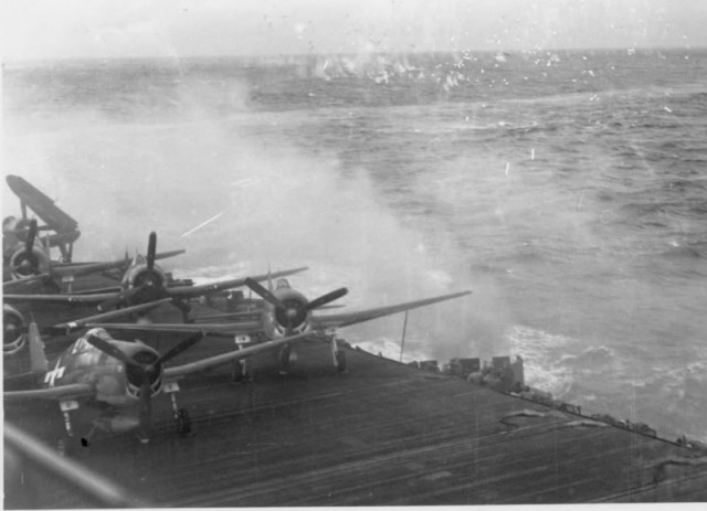 Grumman F6F-5 Hellcats of fighter squadron VF-19 Bulldogs and a Curtiss SB2C Helldiver of bombing squadron VB-19 on the deck of the aircraft carrier USS Lexington (CV-16) during an attack in November 1944.
