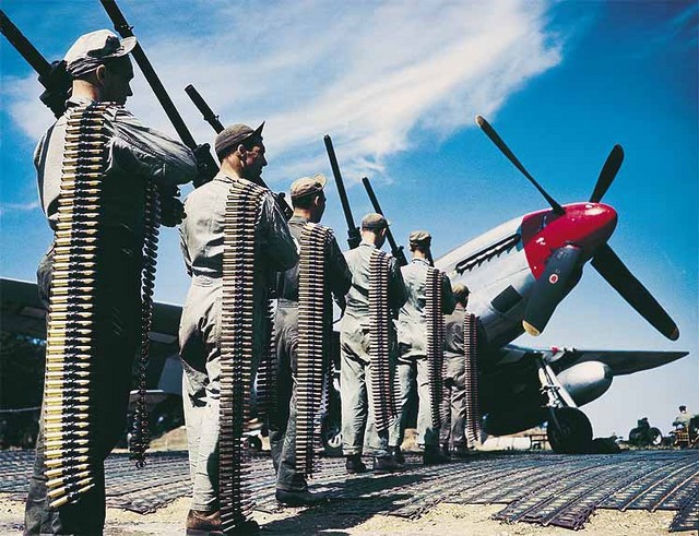 American ground crew preparing to arm P-51 Mustang fighter at an airfield with six M2 machine guns and 0.50 caliber ammunition, date unknown