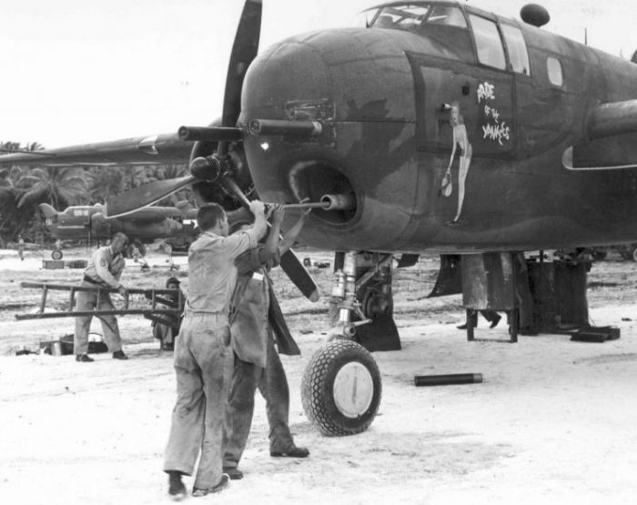 Armorer cleaning the bore of a 75mm cannon mounted in a B-25G Mitchell bomber of the 820th Bomb Squadron, Tarawa, Gilbert Islands; March-April 1944.